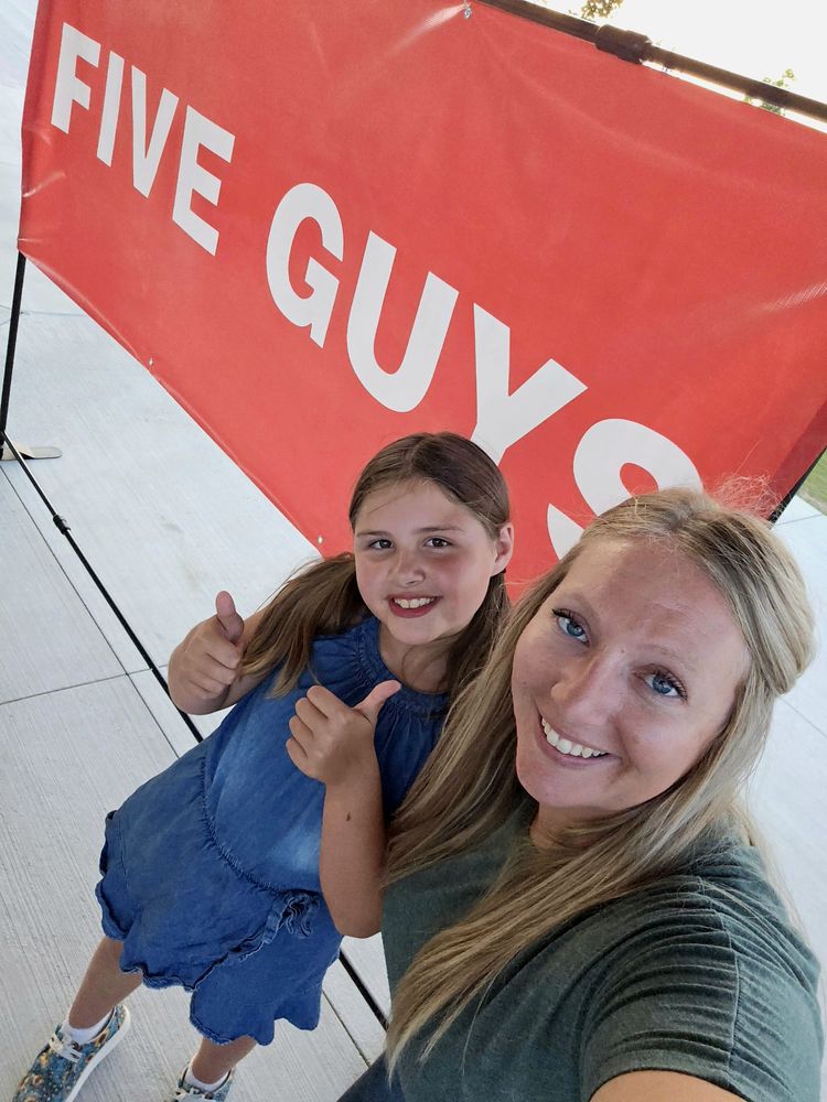 Alena and her daughter today, giving a thumbs up in front of a sponsor banner